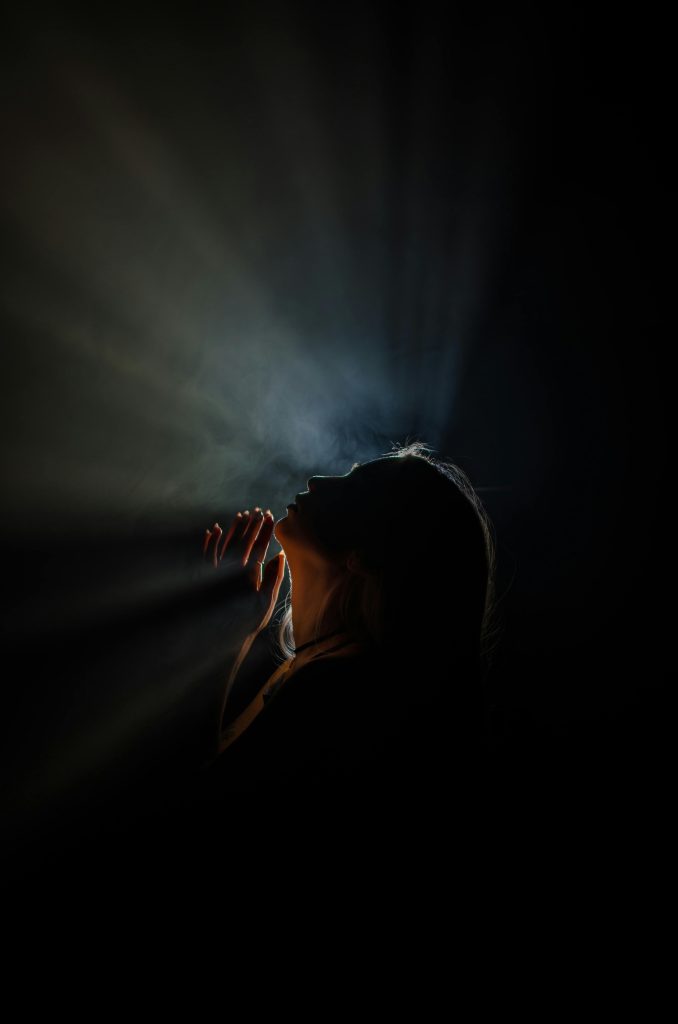 Silhouette of a woman with captivating light rays, creating a dramatic and mysterious atmosphere.